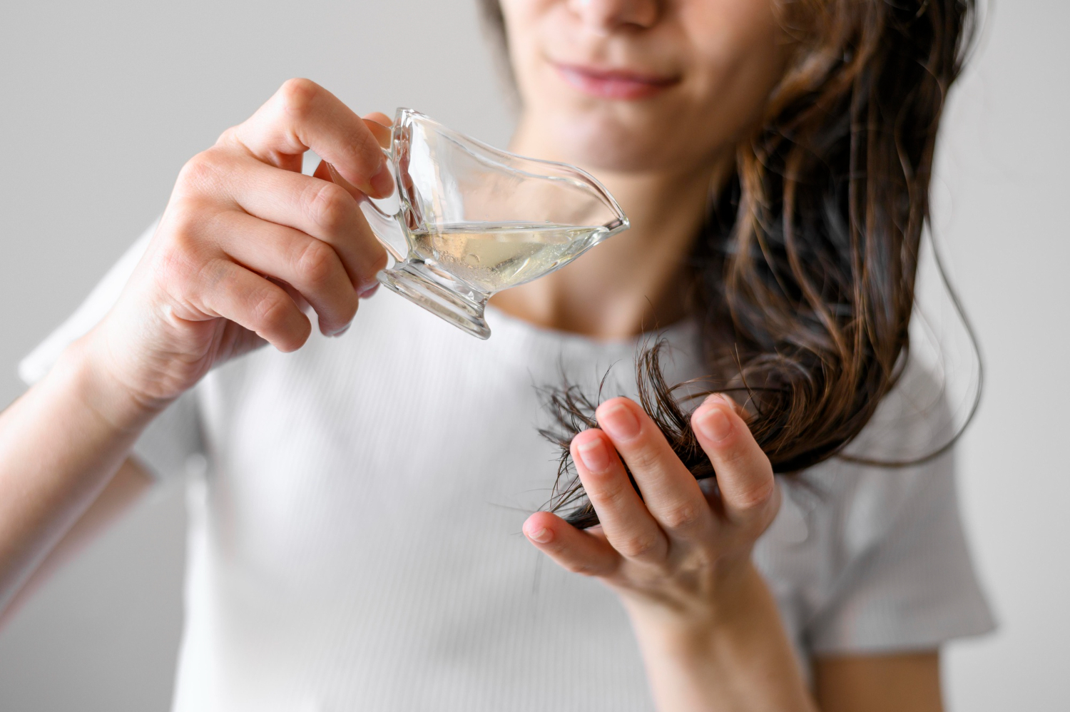 wanita sedang merawat rambutnya dengan mengoleskan vitamin rambut