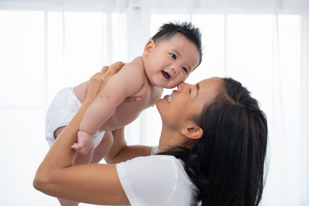 Wanita tersebut menggendong bayi dengan lembut, menunjukkan kasih sayang