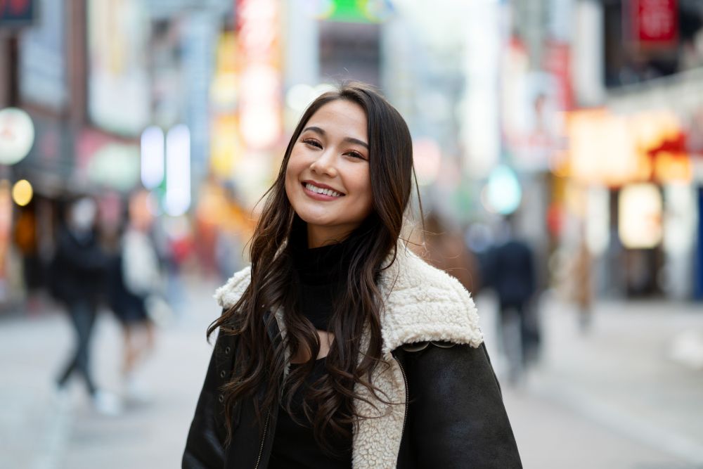 Seorang perempuan muda sedang menghabiskan waktu di kota. Image by freepik